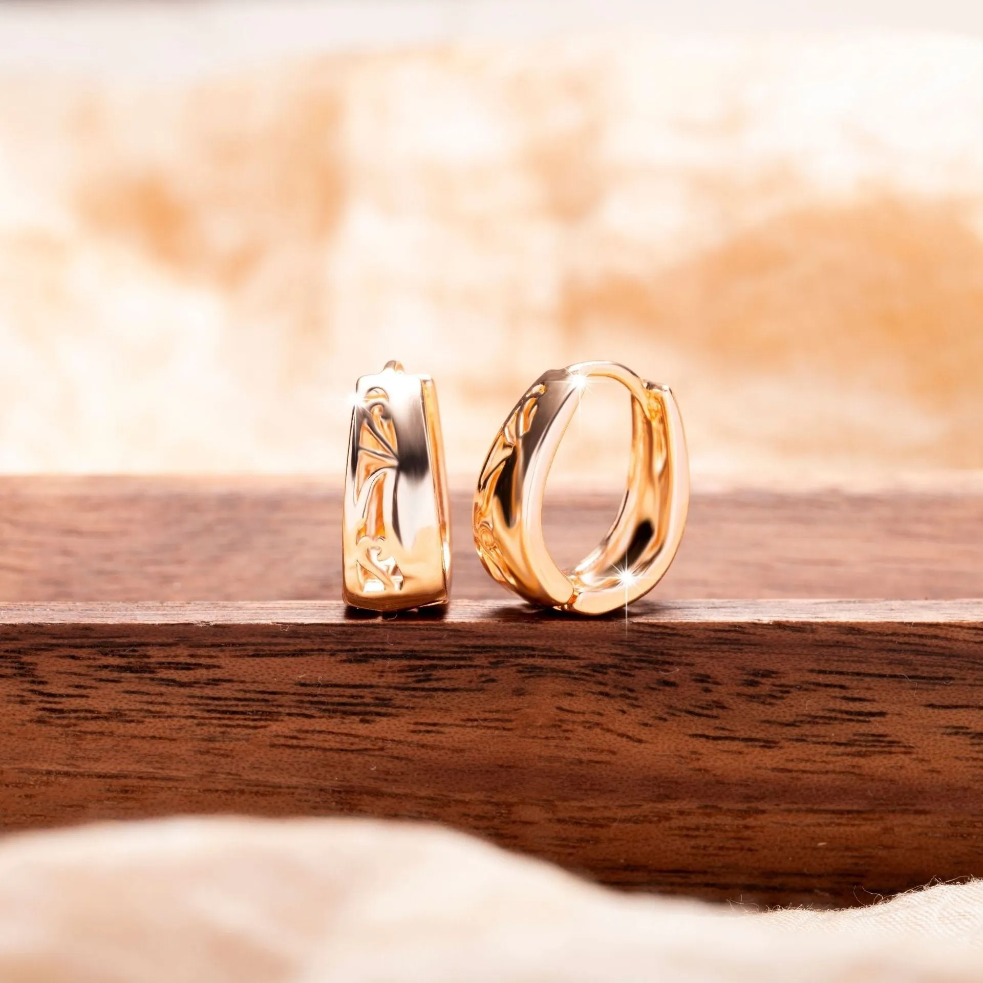 Rose gold hollow carved U-shaped copper earrings on light background