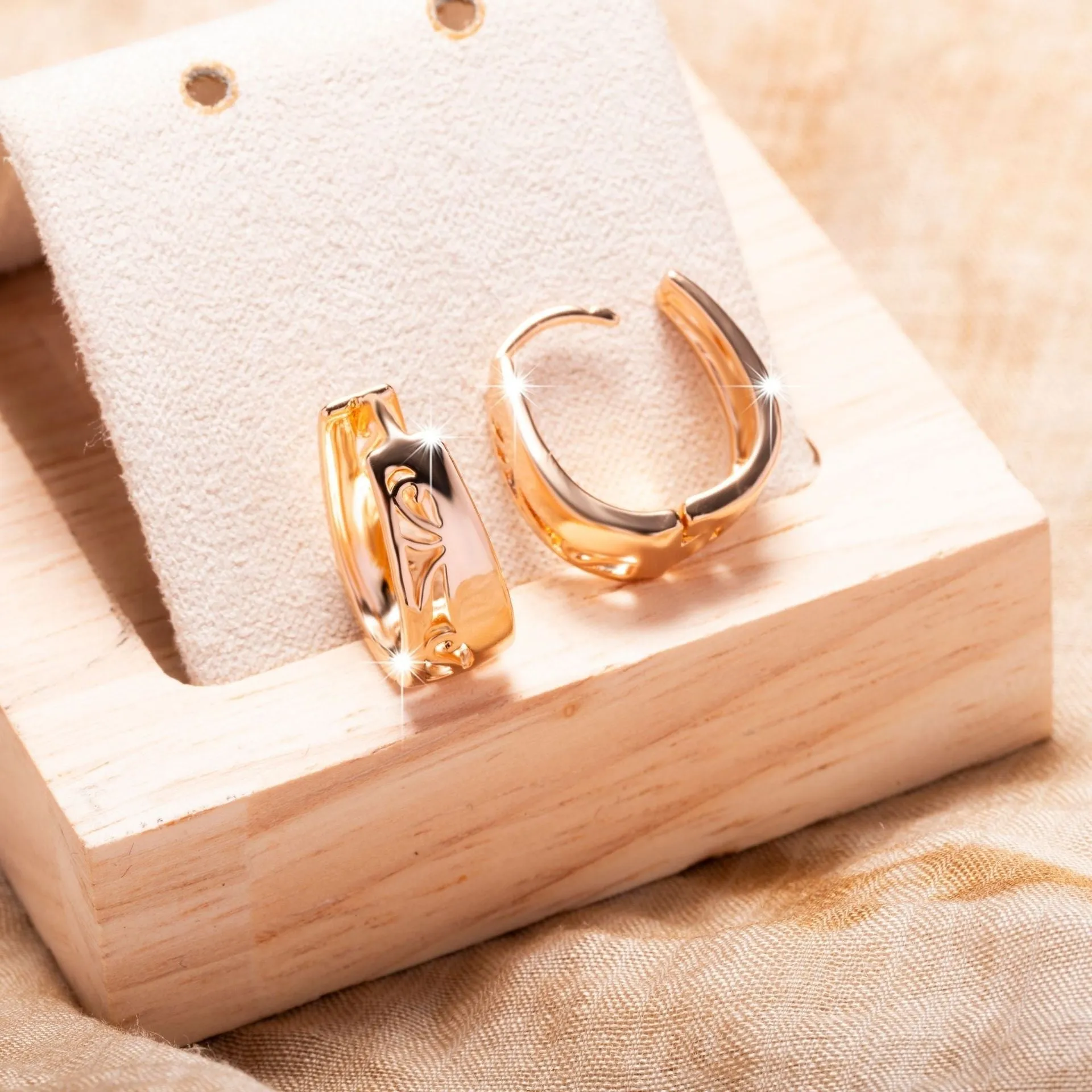 Rose gold hollow carved U-shaped copper earrings on light background