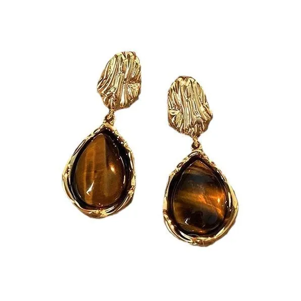 Three pairs of geometric tassel earrings in Maillard, amber, and tigereye colours on a white background