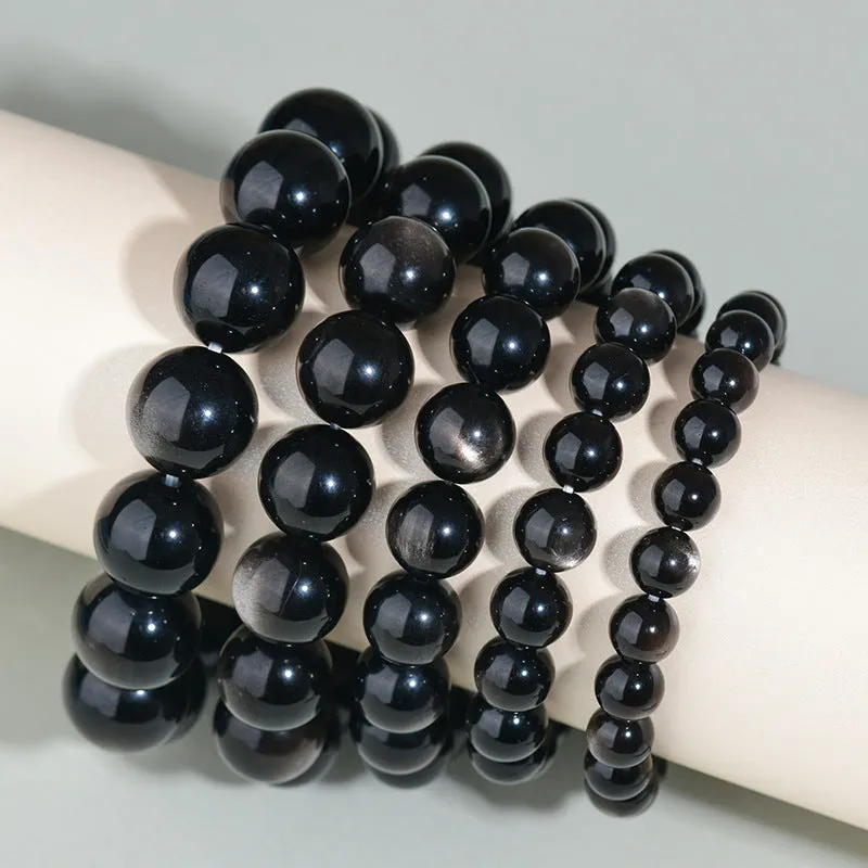 Hand-woven obsidian bracelet with round crystal beads in black stone variations including rainbow eye obsidian