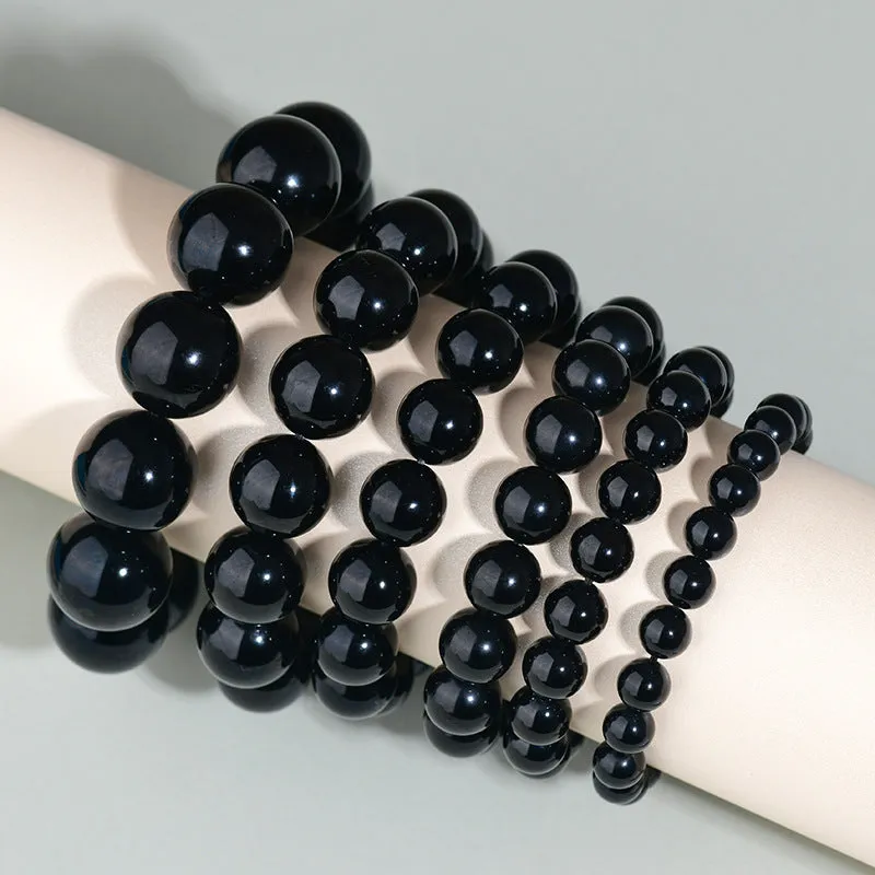 Hand-woven obsidian bracelet with round crystal beads in black stone variations including rainbow eye obsidian