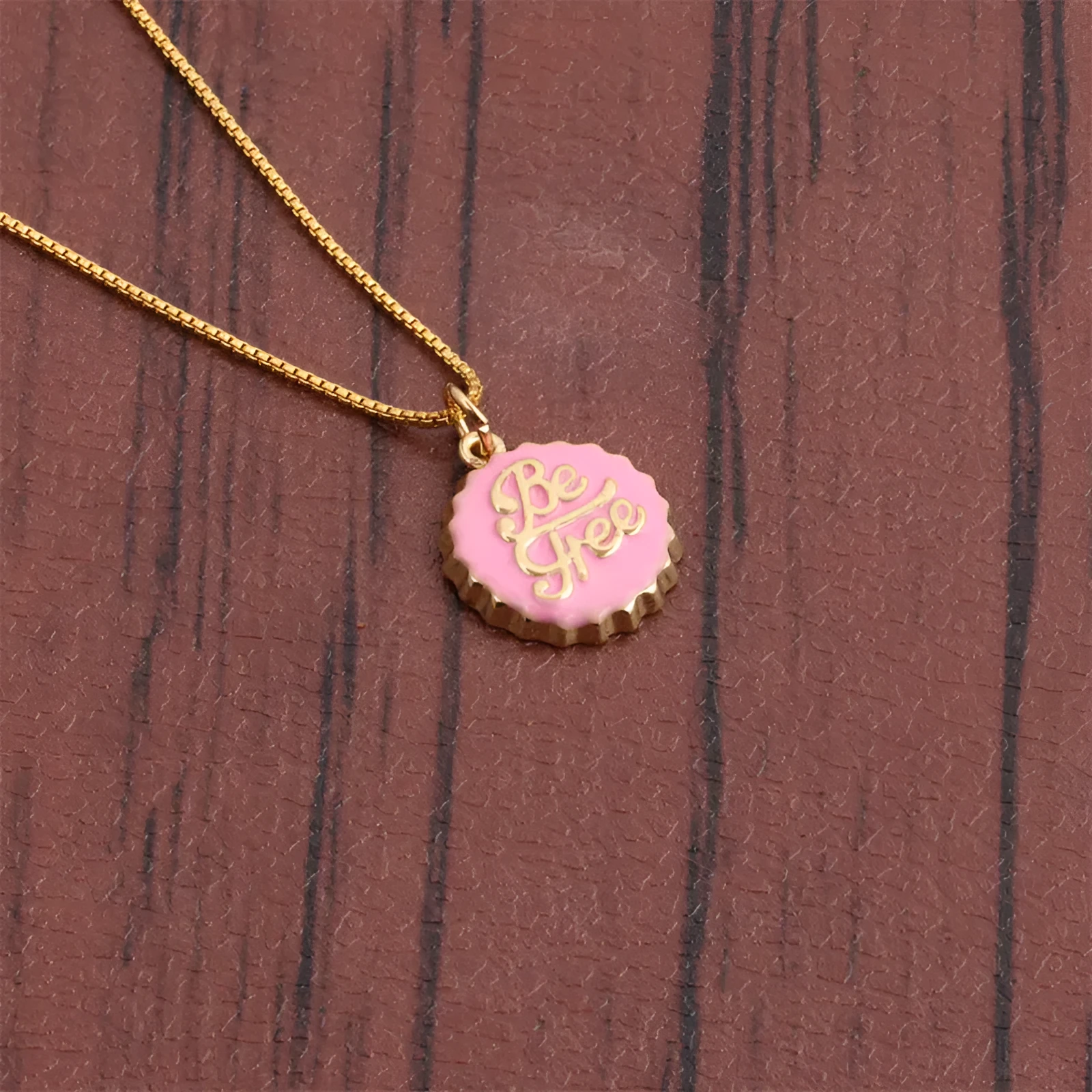 Copper 18K gold plated bottle cap pendant necklace with 40cm box chain on a neutral background