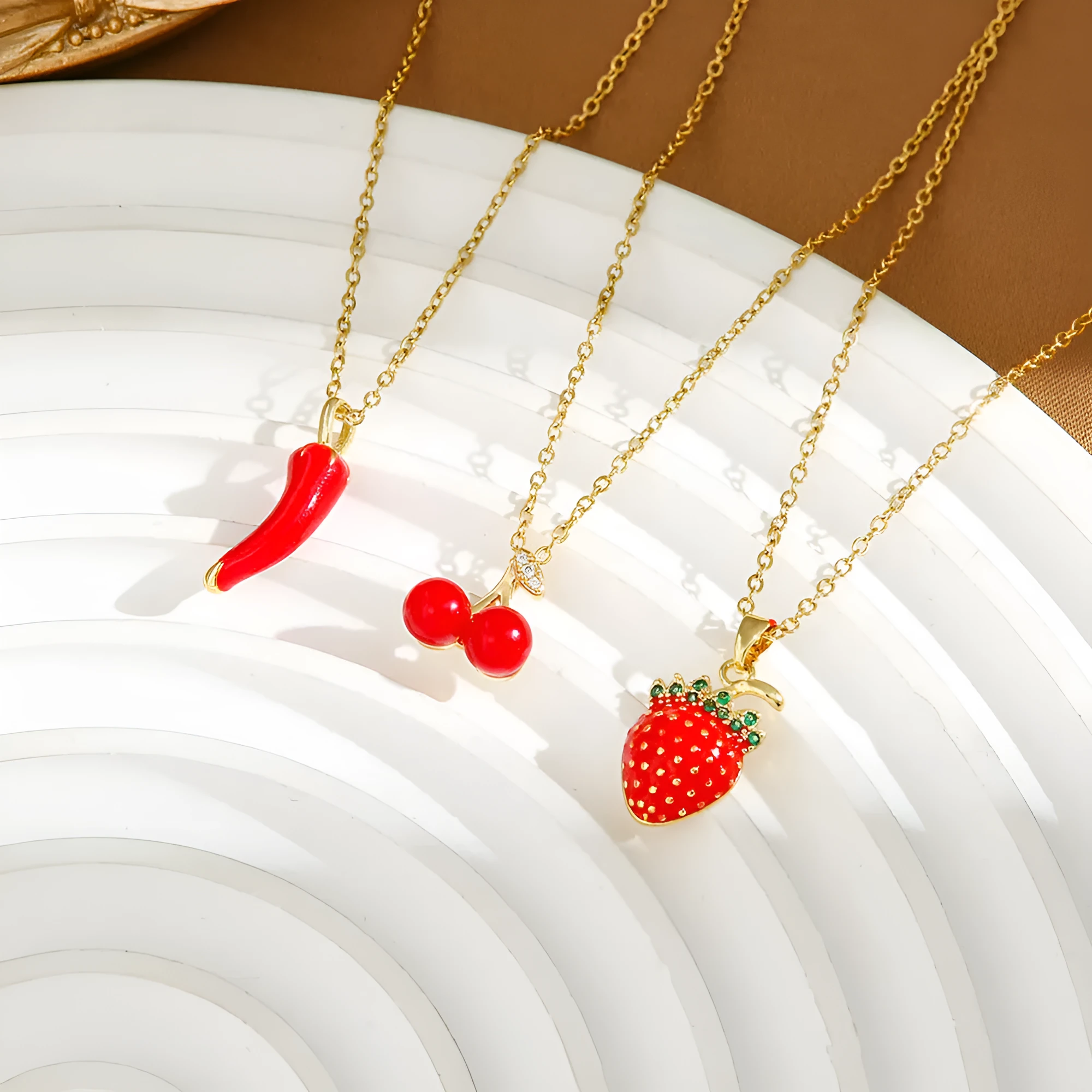Titanium steel fashion necklace with indie cherry pendant on an O-ring chain, shown in golden colour.