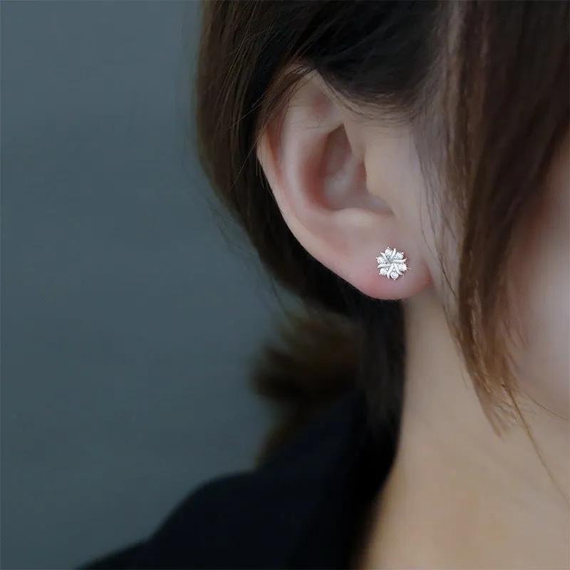 Silver snowflake ear stud earrings for women with zircon detail and copper base, geometric compact design.