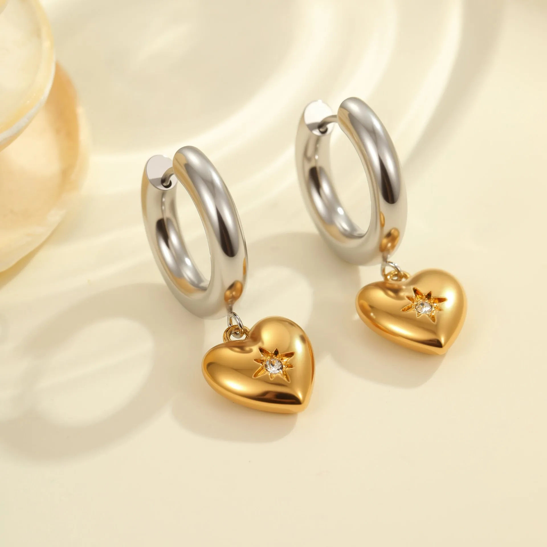 Stainless steel geometric earrings with 18K electroplated finish showing heart and star shapes