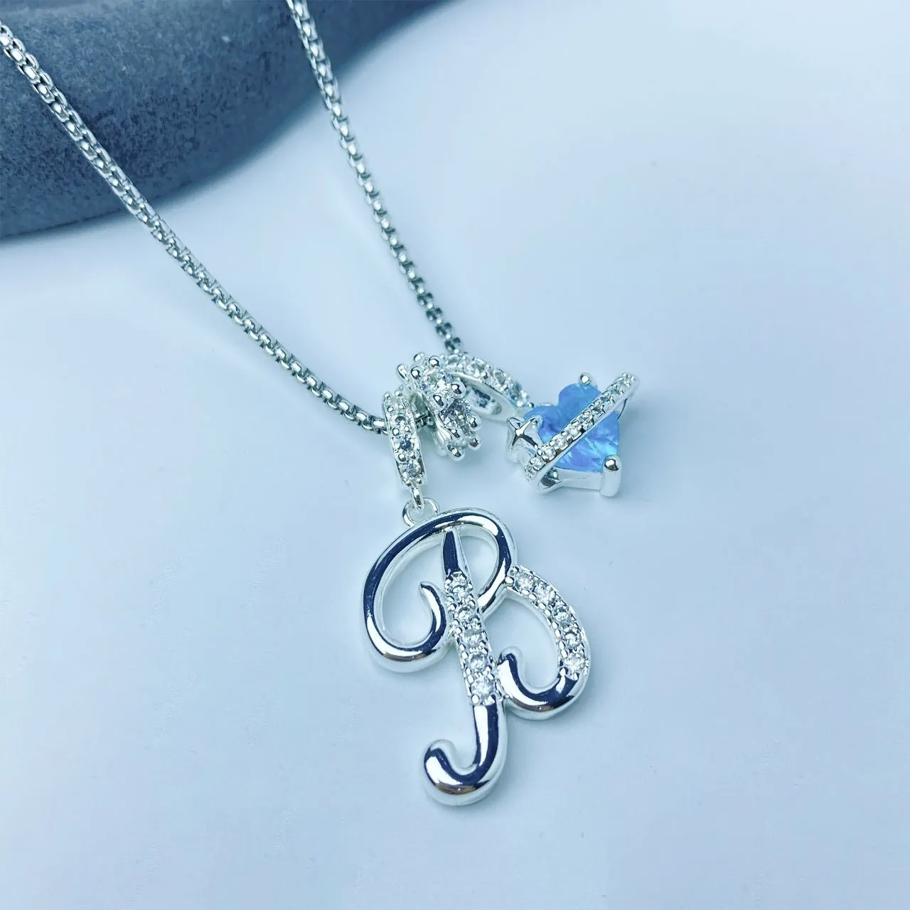 Copper English letter necklace with 26 alphabet charms in gold and silver style on display
