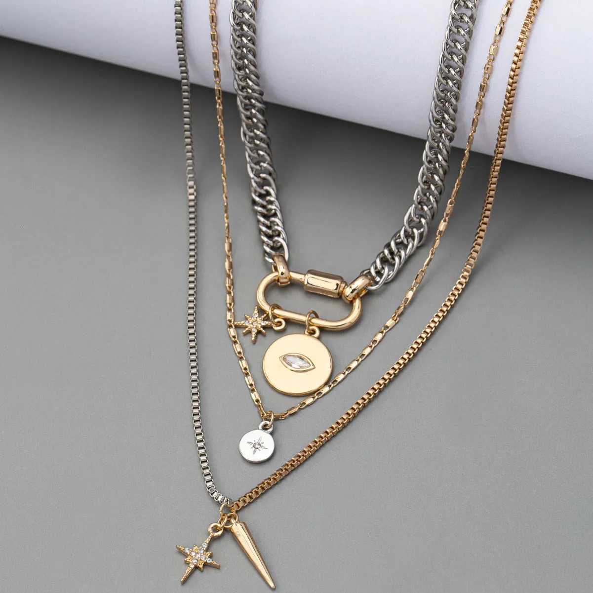 Alloy multi-layer twin necklace with geometric elliptical pendant on a white background