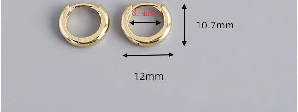 Women's sterling silver round stud earrings in gold colour, 1cm diameter, on a white surface