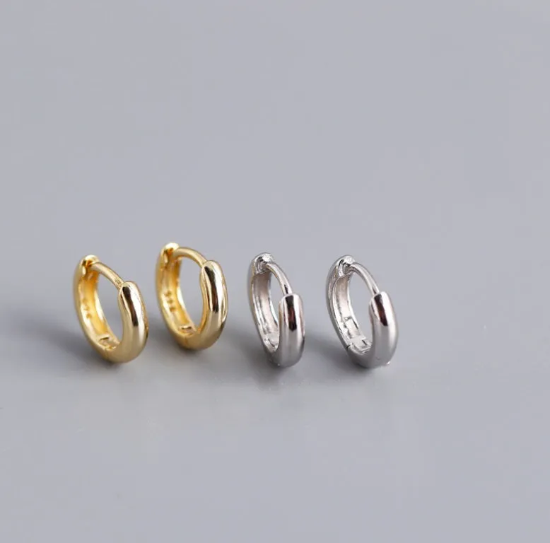 Women's sterling silver round stud earrings in gold colour, 1cm diameter, on a white surface