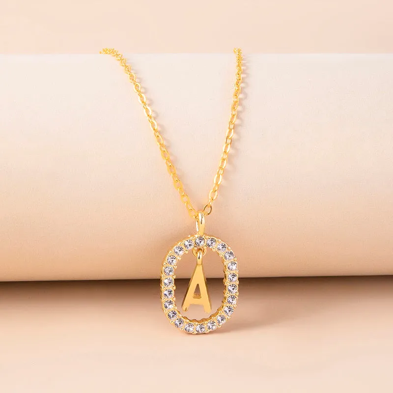 Gold crystal letter necklace with rhinestone initial on oval pendant and O-chain
