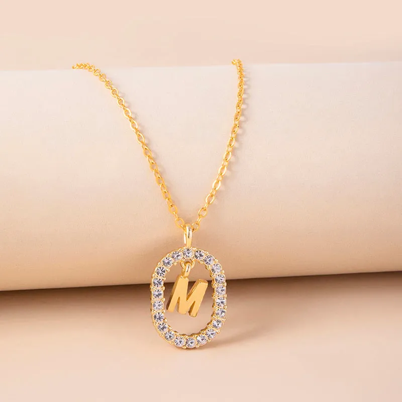 Gold crystal letter necklace with rhinestone initial on oval pendant and O-chain