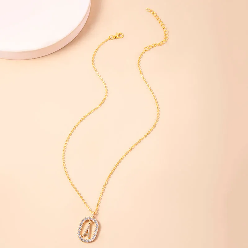 Gold crystal letter necklace with rhinestone initial on oval pendant and O-chain