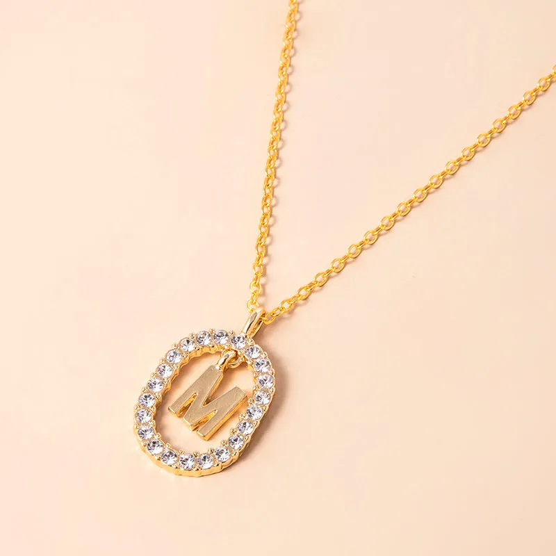 Gold crystal letter necklace with rhinestone initial on oval pendant and O-chain