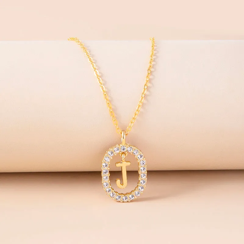 Gold crystal letter necklace with rhinestone initial on oval pendant and O-chain
