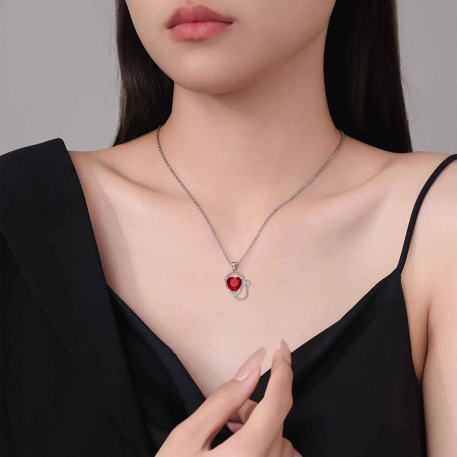 Red diamond women's necklace with stethoscope, wing, and cross pendant design on a copper chain.