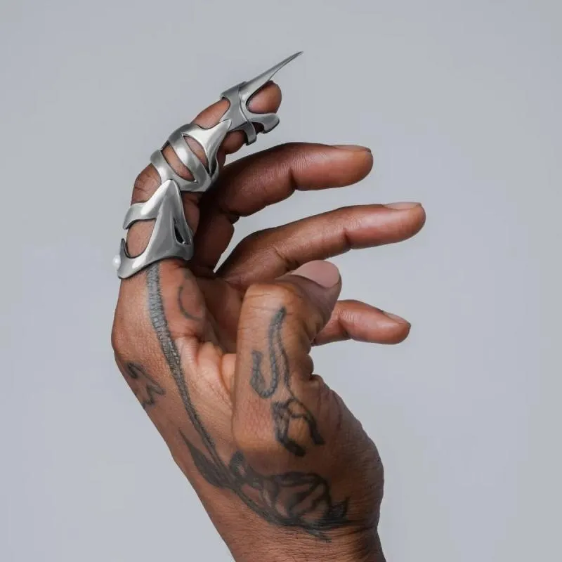 Silver-coloured alloy punk armour finger stall ring on a hand.