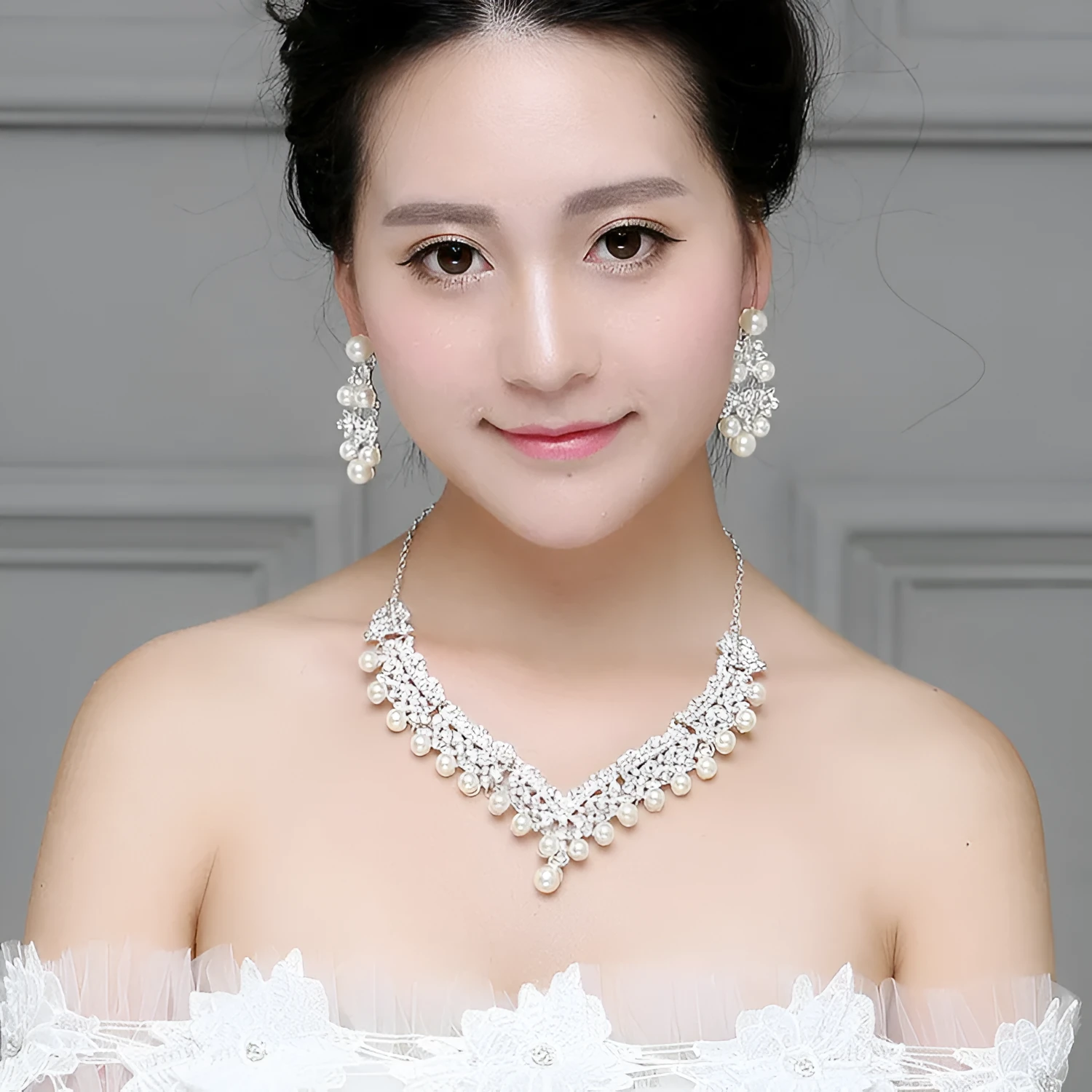 White pearl and crystal bridal set with necklace, earrings, and hair accessory on display