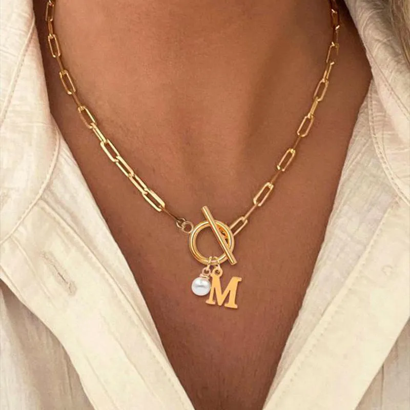 Stainless steel clip chain necklace with raised letter A pendant and imitation pearl in gold colour on a white background