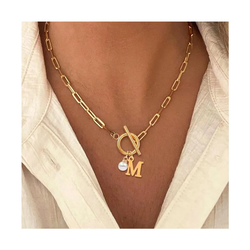 Stainless steel clip chain necklace with raised letter A pendant and imitation pearl in gold colour on a white background