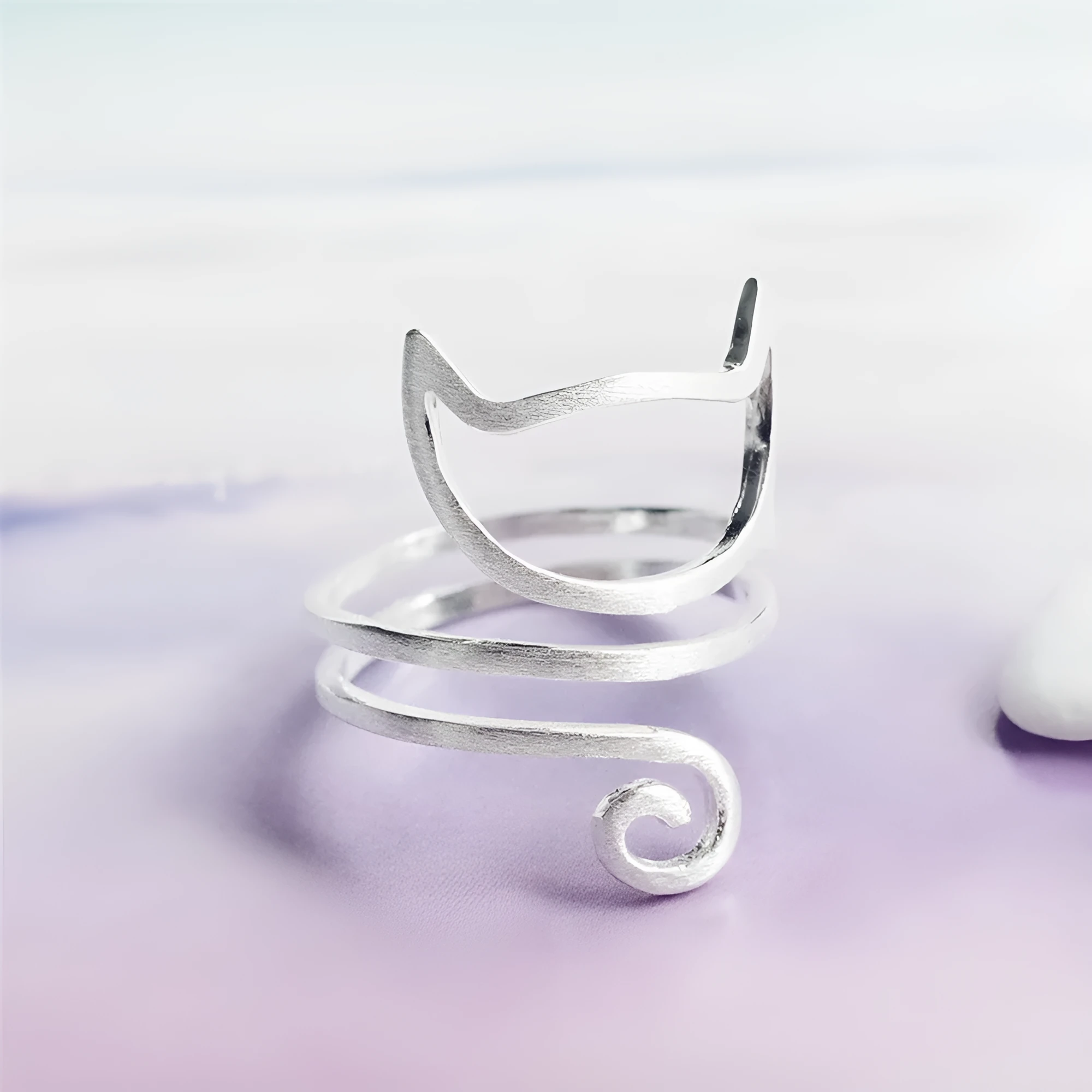 S925 silver adjustable cat ring with brushed winding design on a neutral background