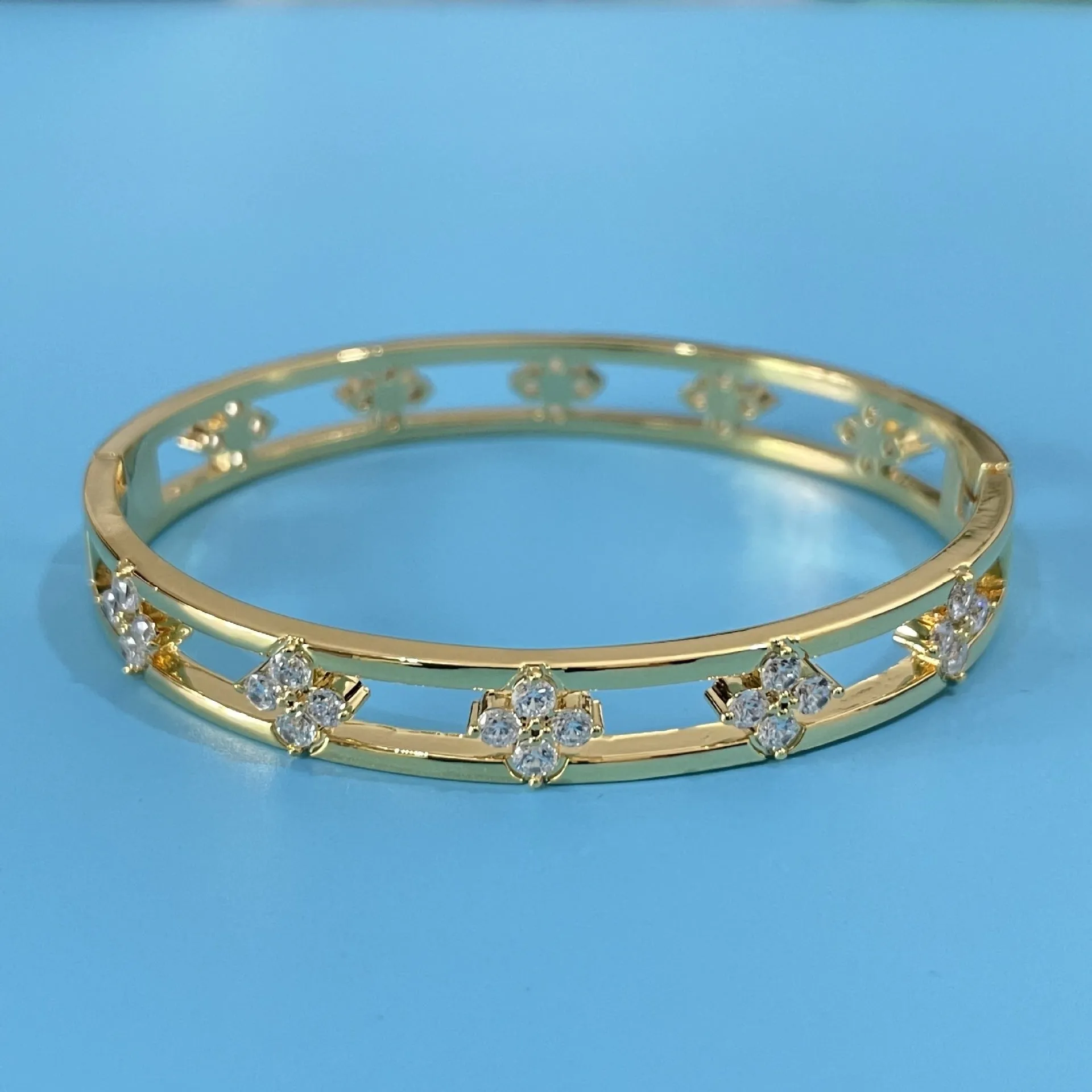 Hollow women's bracelet with four-leaf clover charm containing inlaid AAA zircon gemstones