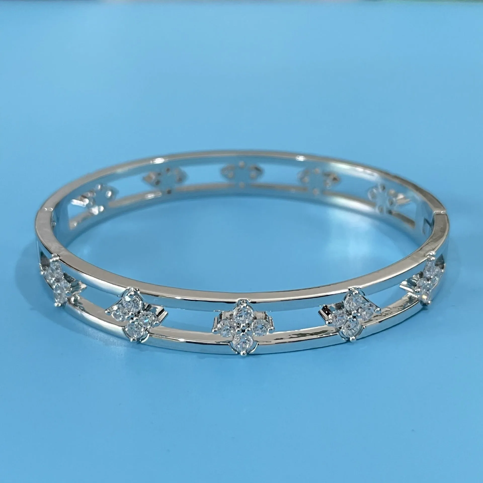 Hollow women's bracelet with four-leaf clover charm containing inlaid AAA zircon gemstones