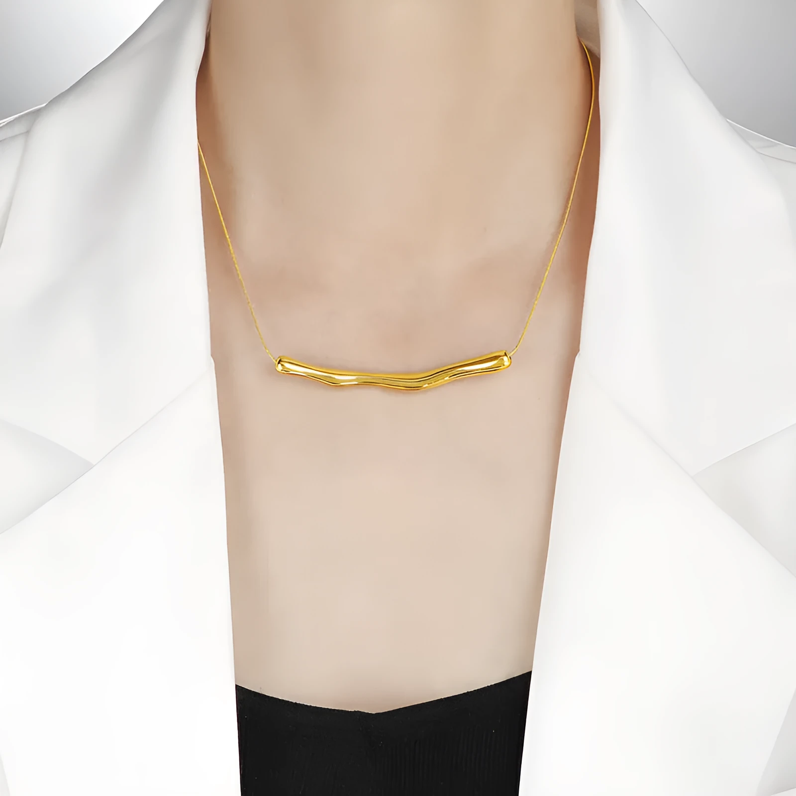 Close-up of a women's titanium steel necklace with an irregular pleated textured pendant in a gold tone.