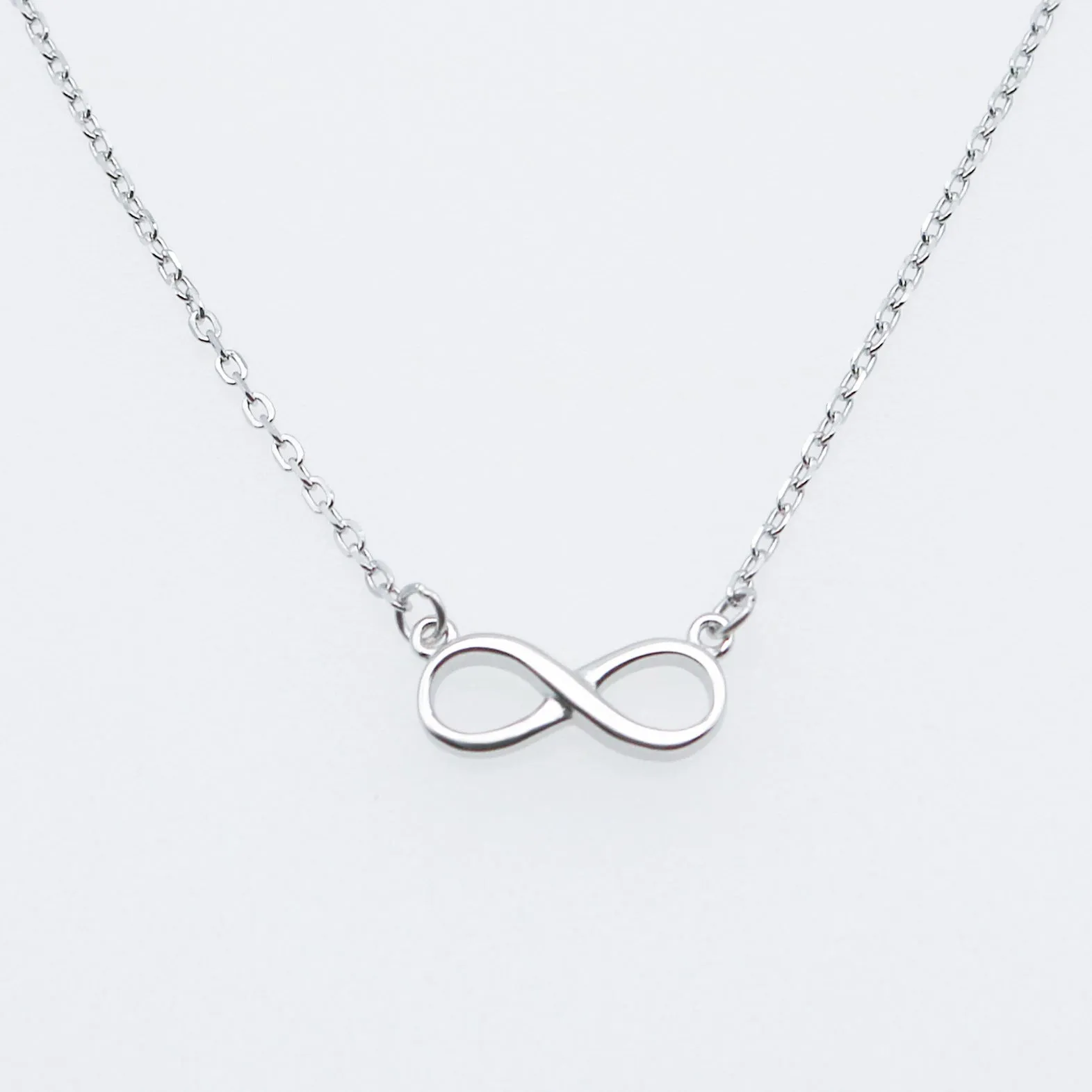 925 silver through-the-body pendant necklace with adjustable chain in platinum finish on collarbone