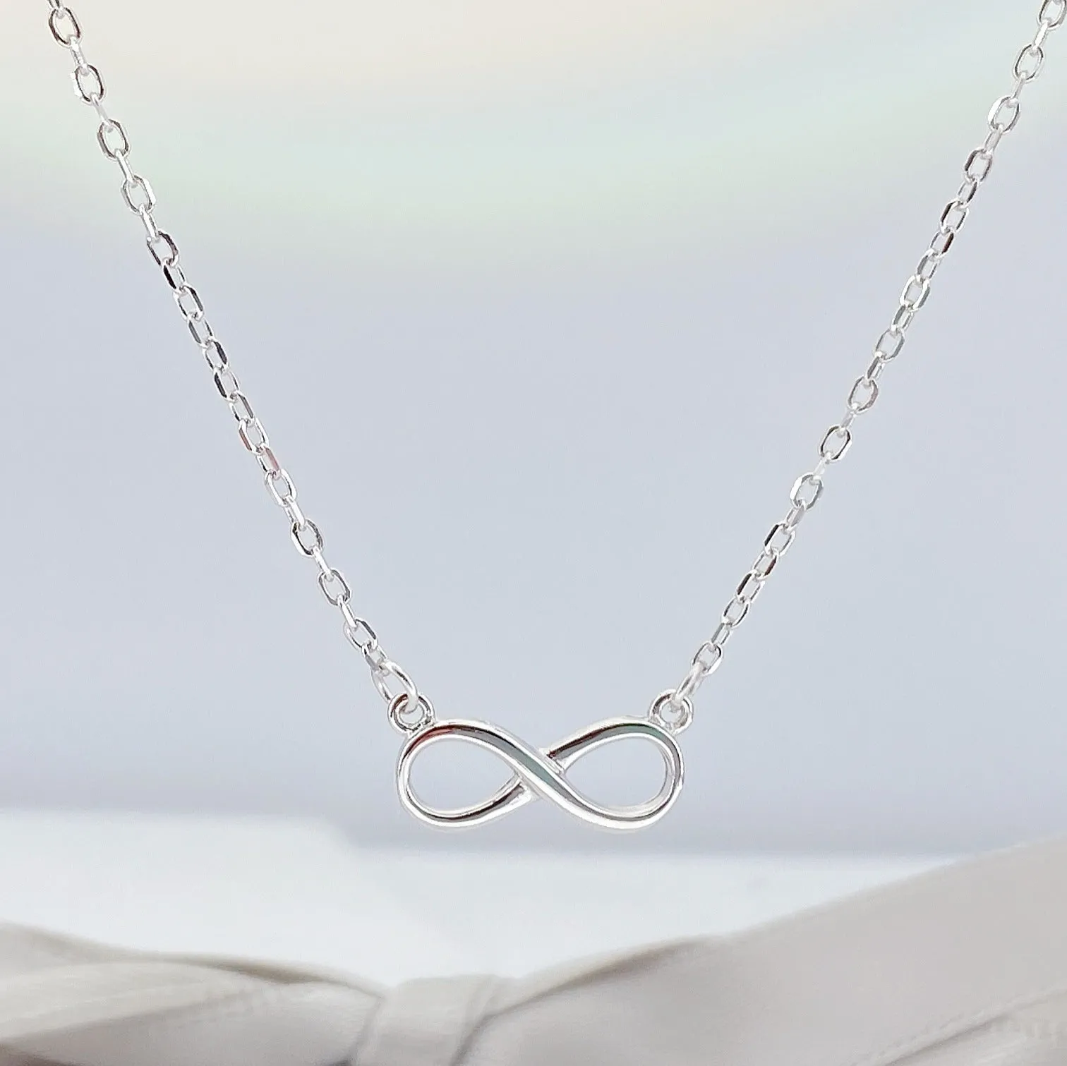 925 silver through-the-body pendant necklace with adjustable chain in platinum finish on collarbone