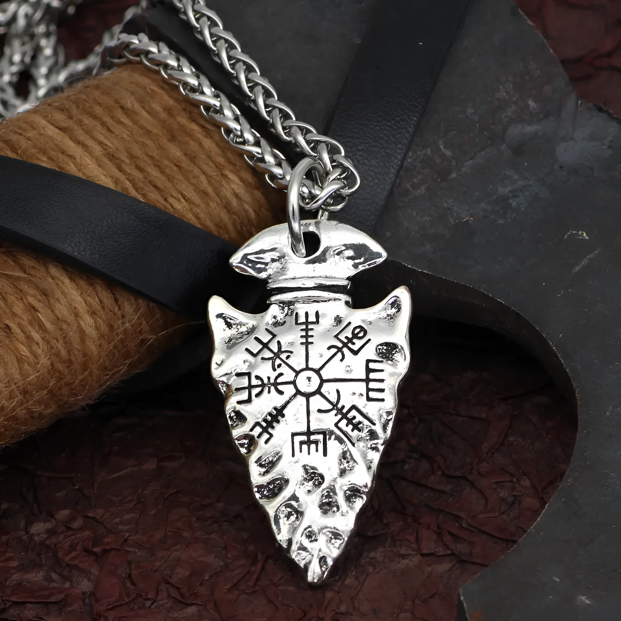 Alloy compass pendant necklace with twisted chain on a flat surface showing silver finish