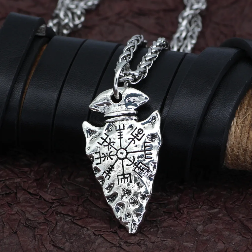 Alloy compass pendant necklace with twisted chain on a flat surface showing silver finish