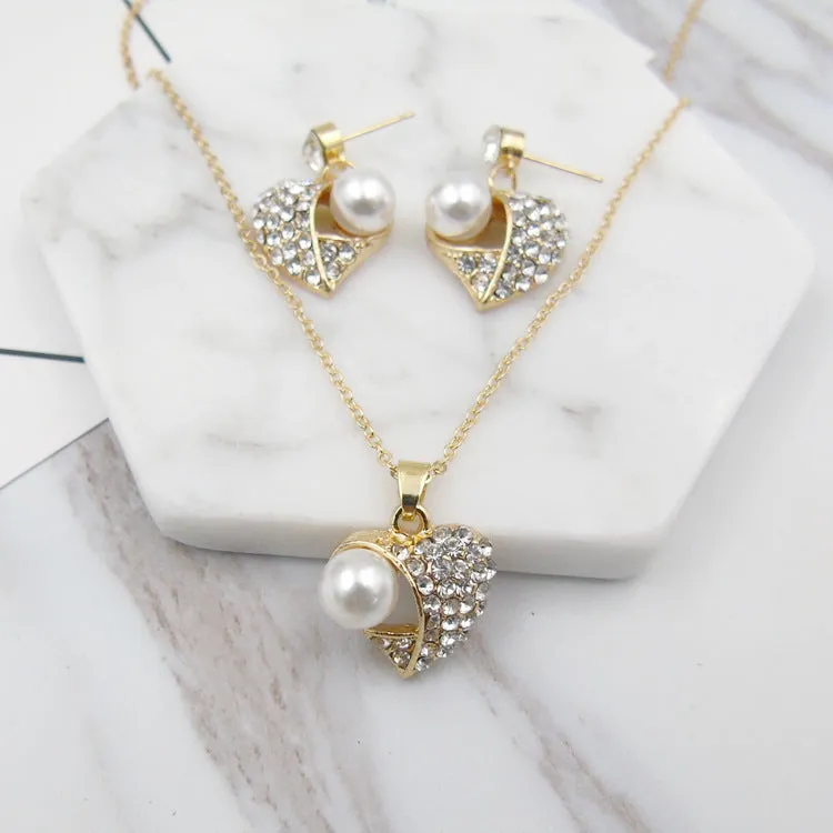 Gold heart pearl jewellery set with alloy necklace and earrings on display