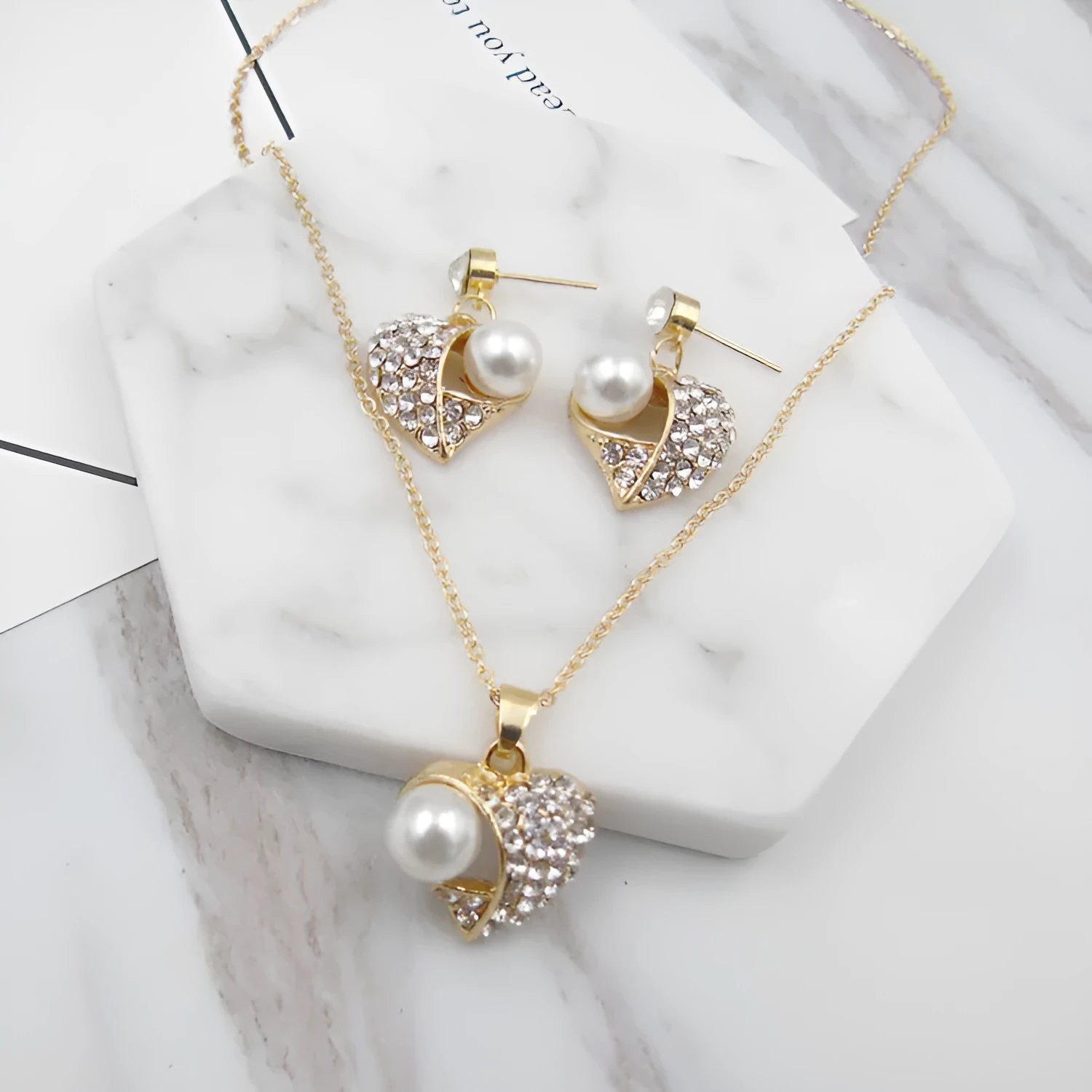 Gold heart pearl jewellery set with alloy necklace and earrings on display