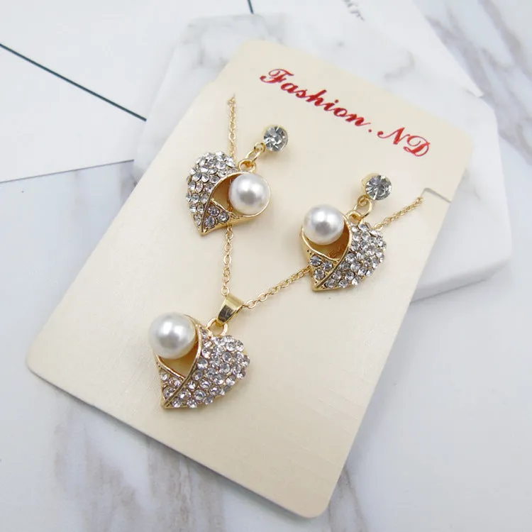 Gold heart pearl jewellery set with alloy necklace and earrings on display