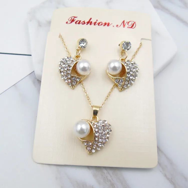 Gold heart pearl jewellery set with alloy necklace and earrings on display