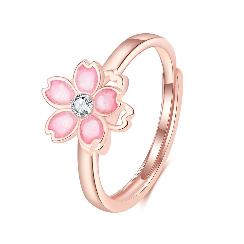 Cherry blossom rotatable ring with rose gold finish, adjustable opening, and silver base shown on a finger