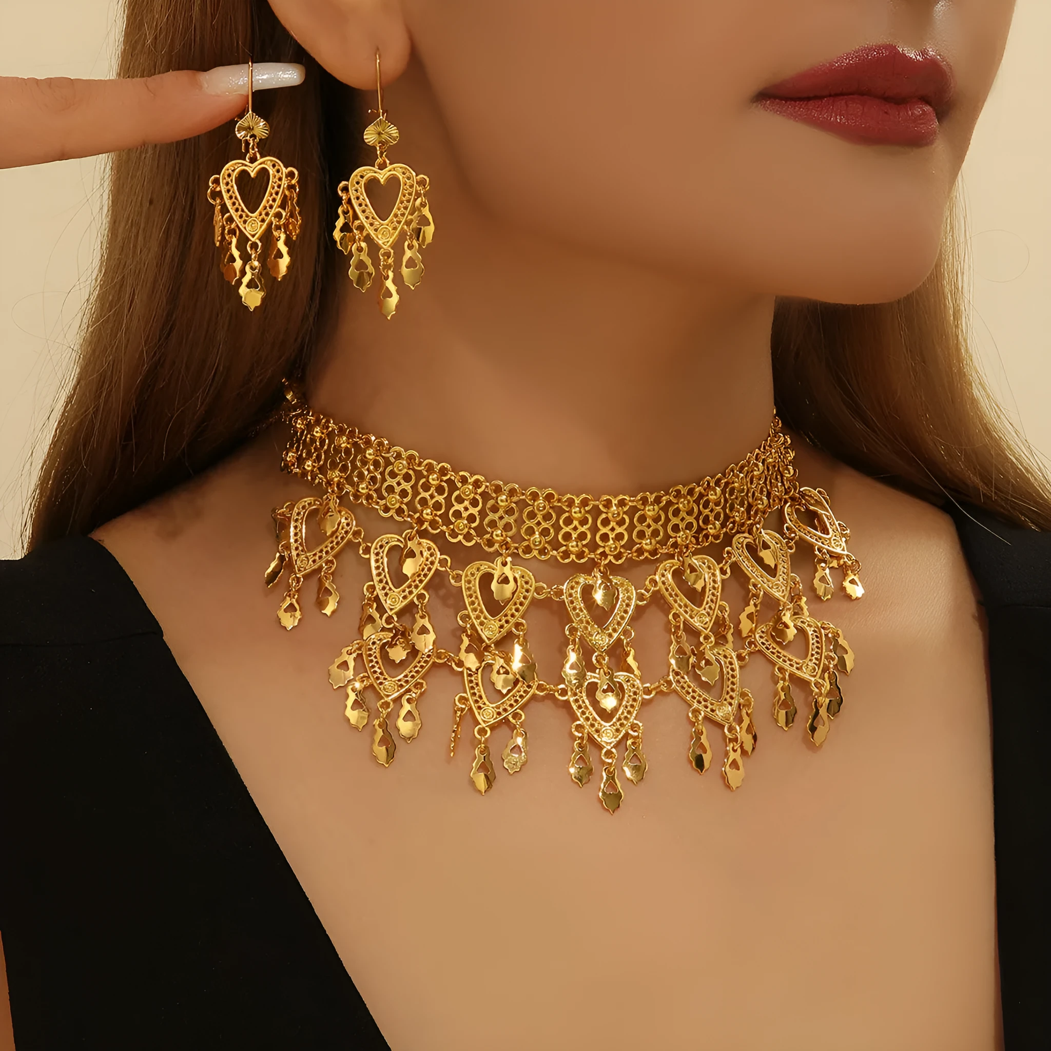 Gold alloy heart-shaped hollow necklace and matching earrings set on display with multiple hanging leaf ornaments