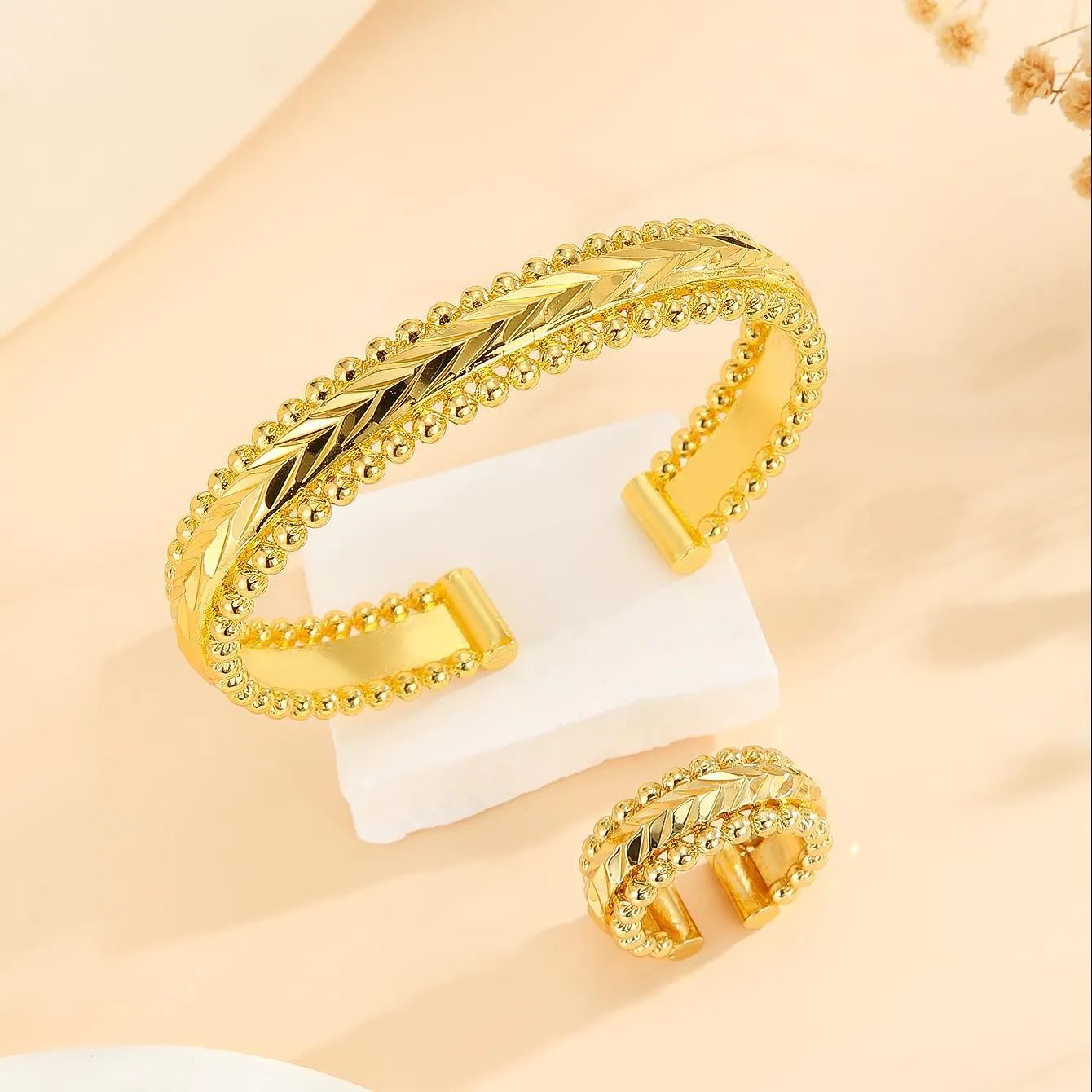 2pcs vintage gold plated bracelet and ring set with floral design and bead edges on a white background