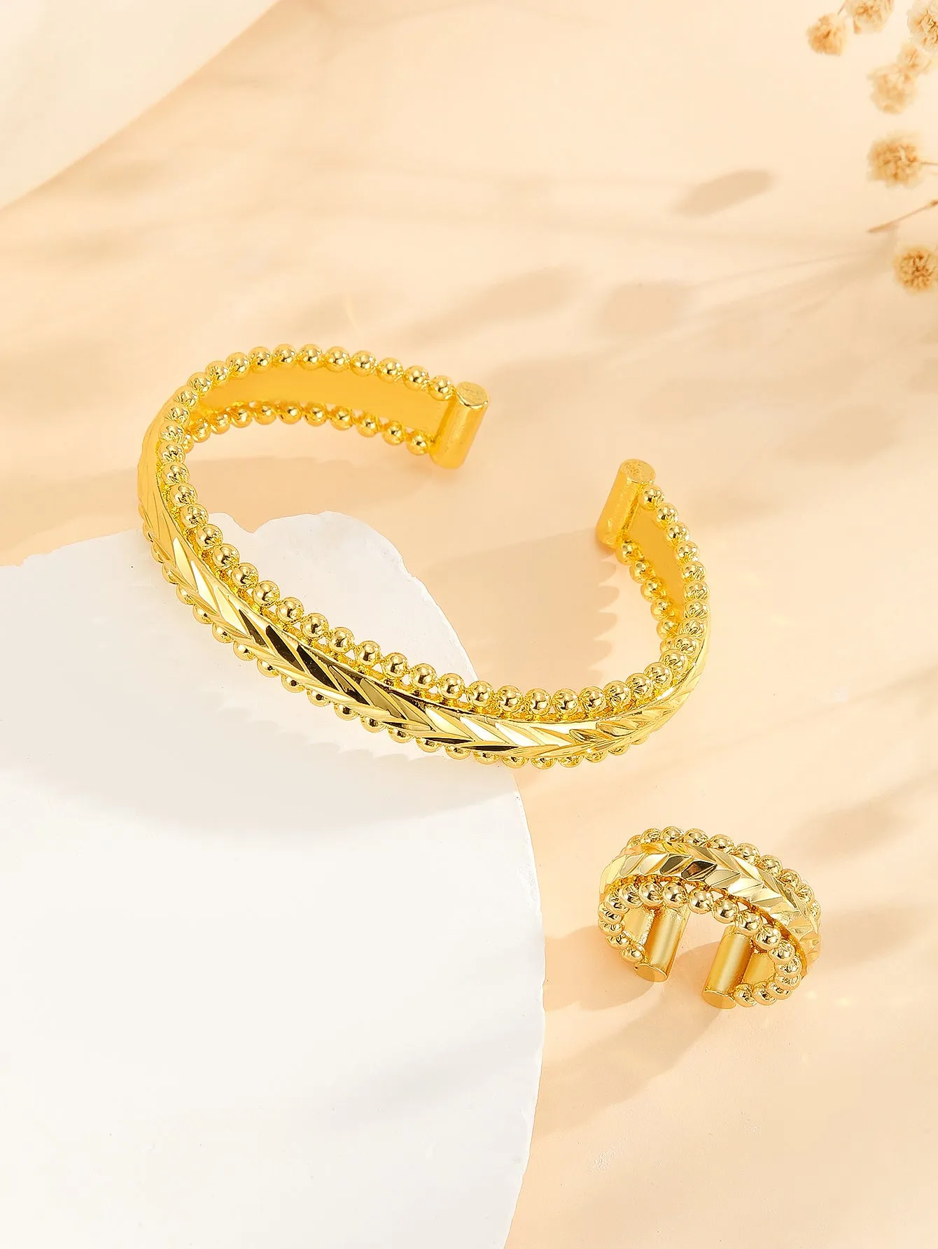 2pcs vintage gold plated bracelet and ring set with floral design and bead edges on a white background