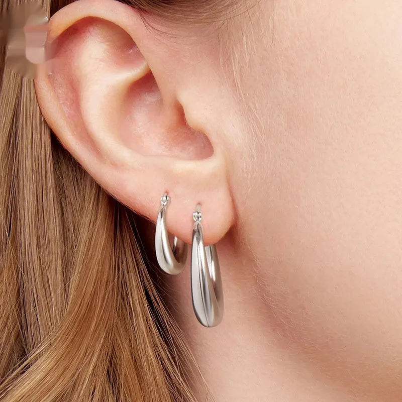 A pair of copper geometric ring ear clips with a silver needle, shown in large, medium, and small sizes.
