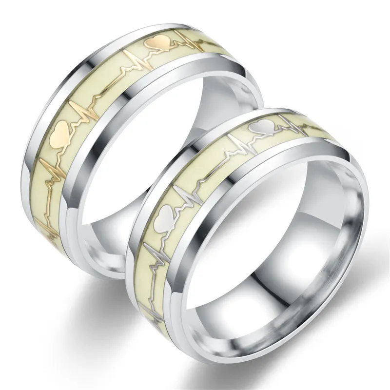 Gold heart-shaped stainless steel lovers ring with luminous glow, on white background