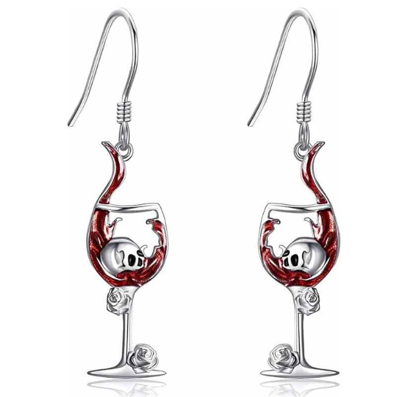 A pair of silver-toned drop earrings featuring a detailed geometry skull design combined with a wine glass shape.