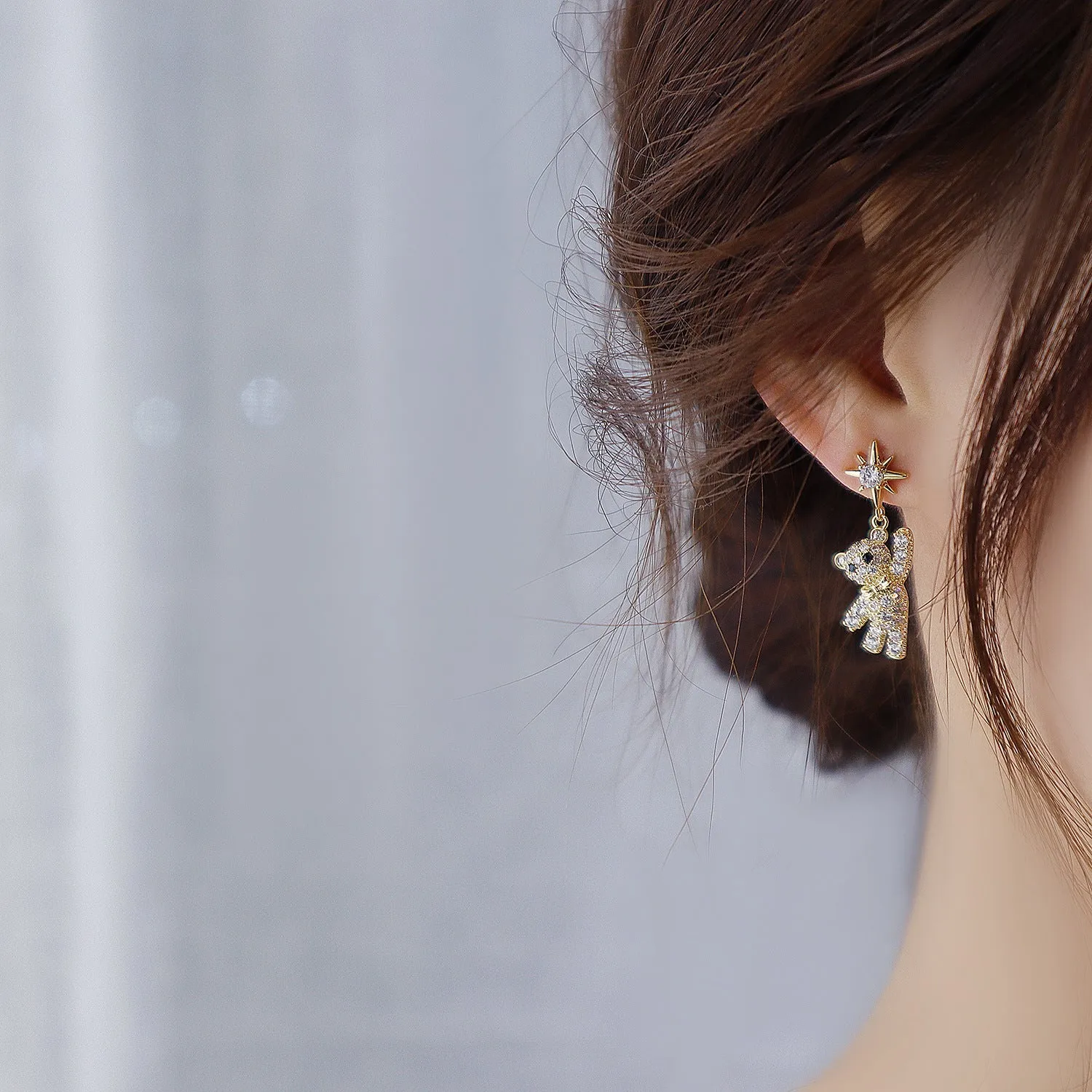 Star-shaped stud earrings in gold with diamond-cut metal and inlaid artificial stones