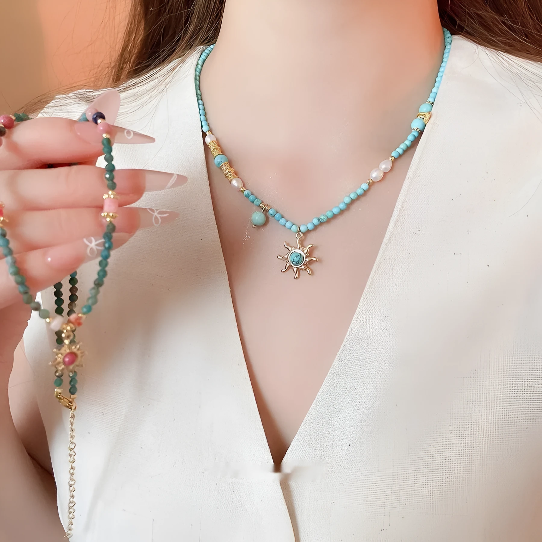 Freshwater pearl necklace with a blue stone sun pendant on an adjustable gold-toned chain.
