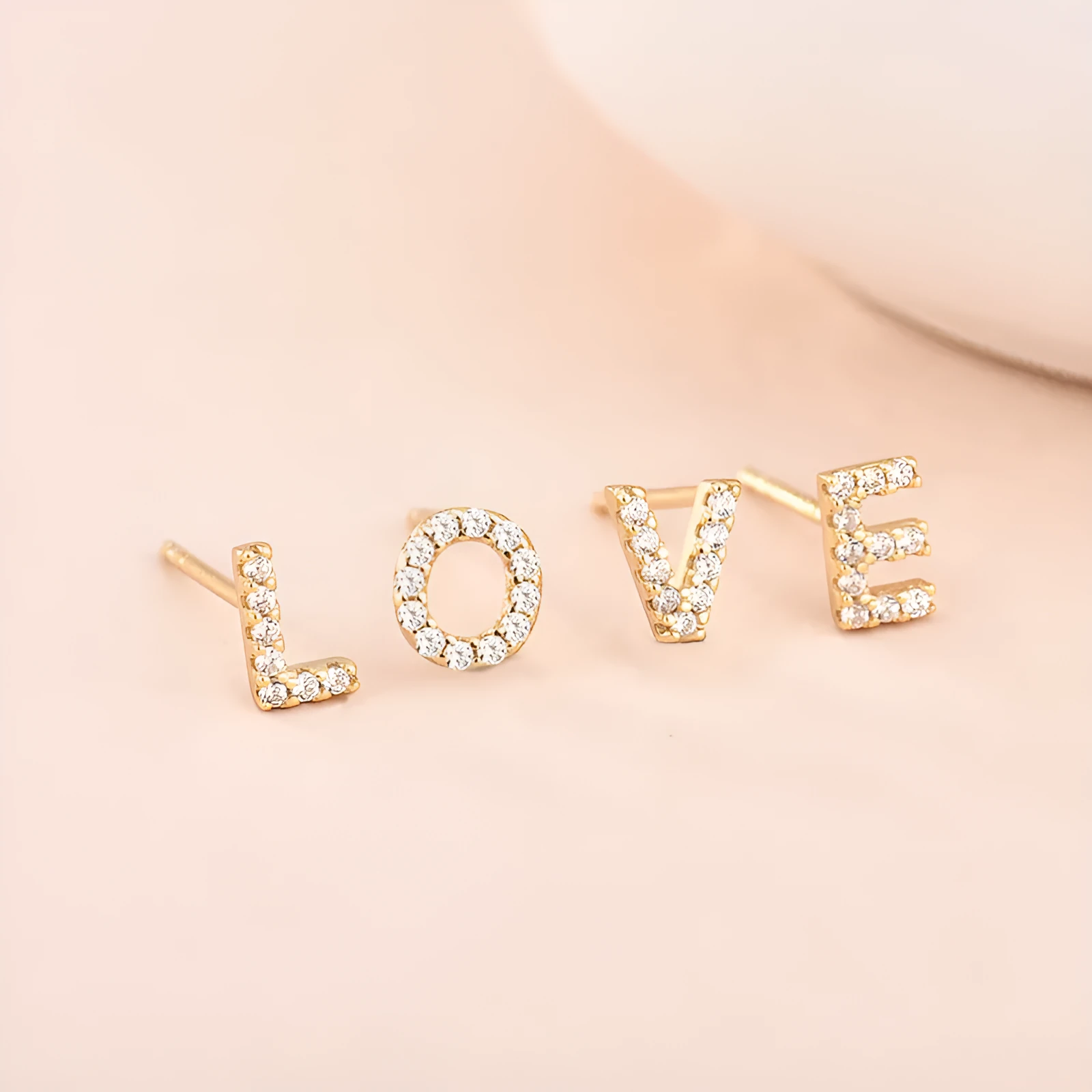 Gold plated brass earring in the shape of the letter A, set with a sparkling zircon stone.
