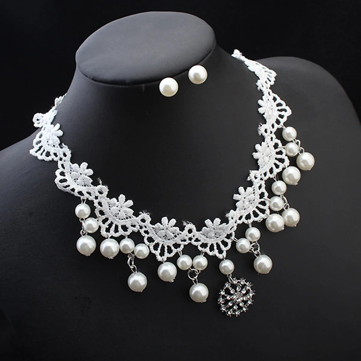 Three-piece white pearl jewellery set with necklace, earrings, and bracelet on display