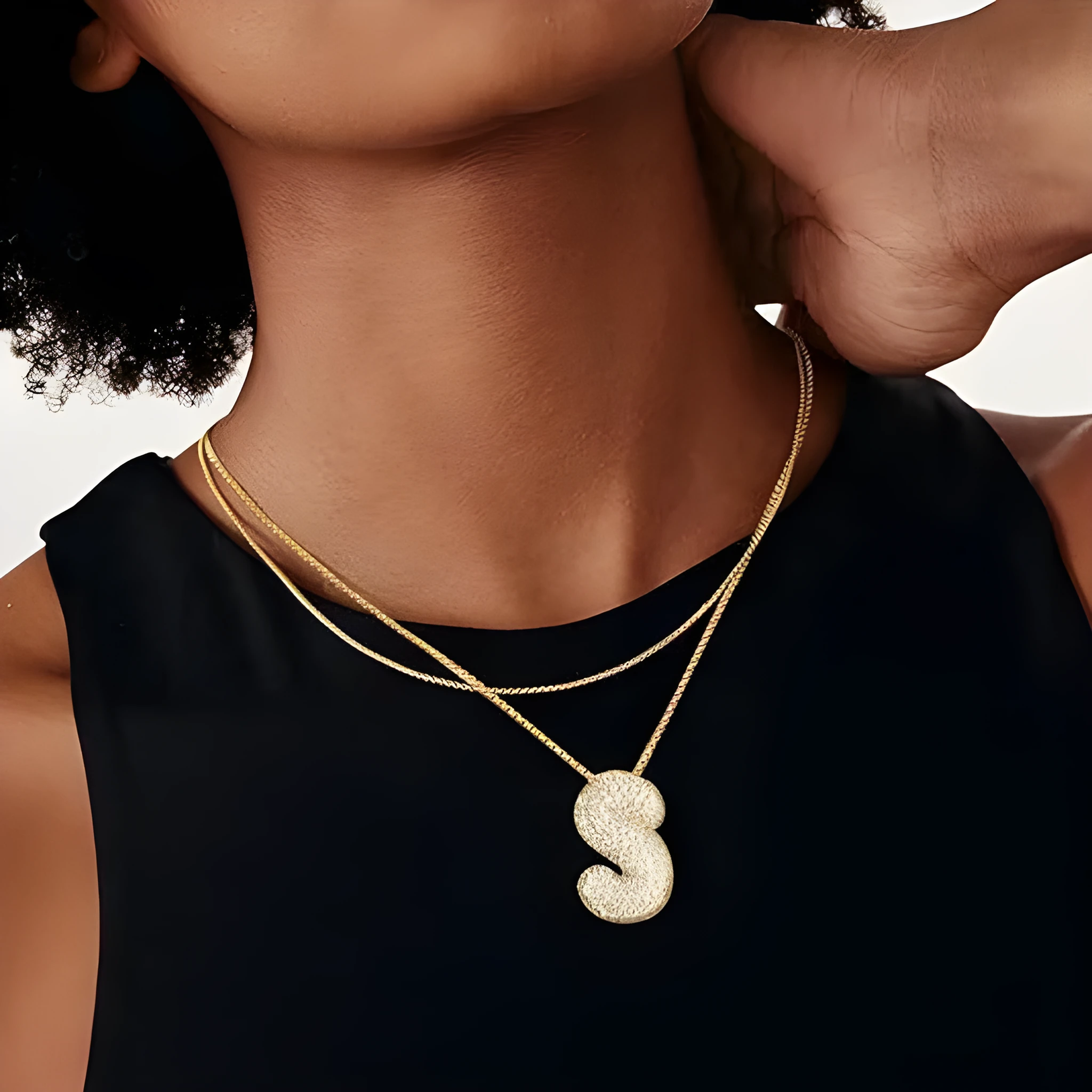 Brass zircon balloon English letter necklace in gold finish, copper base with inlaid zircon stones, on a woman's collarbone