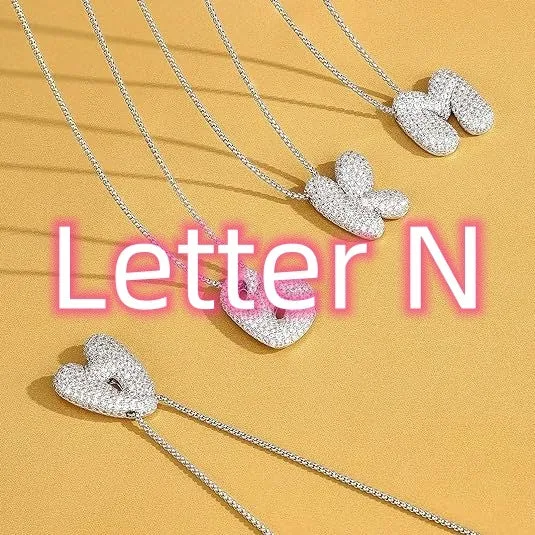 Brass zircon balloon English letter necklace in gold finish, copper base with inlaid zircon stones, on a woman's collarbone