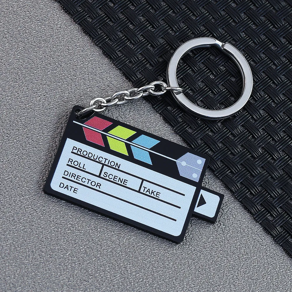 Custom film keychain with ten photographs on a film strip and a rewinder accessory