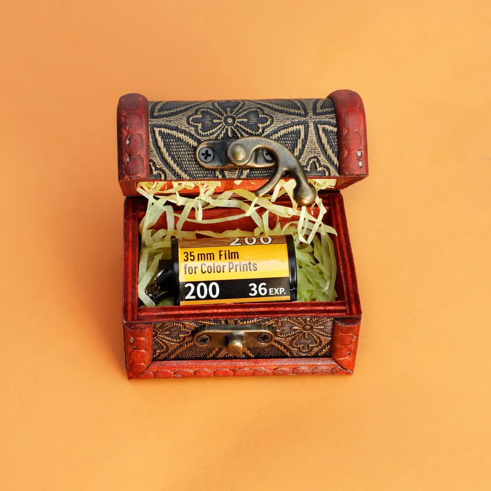 Custom film keychain with ten photographs on a film strip and a rewinder accessory